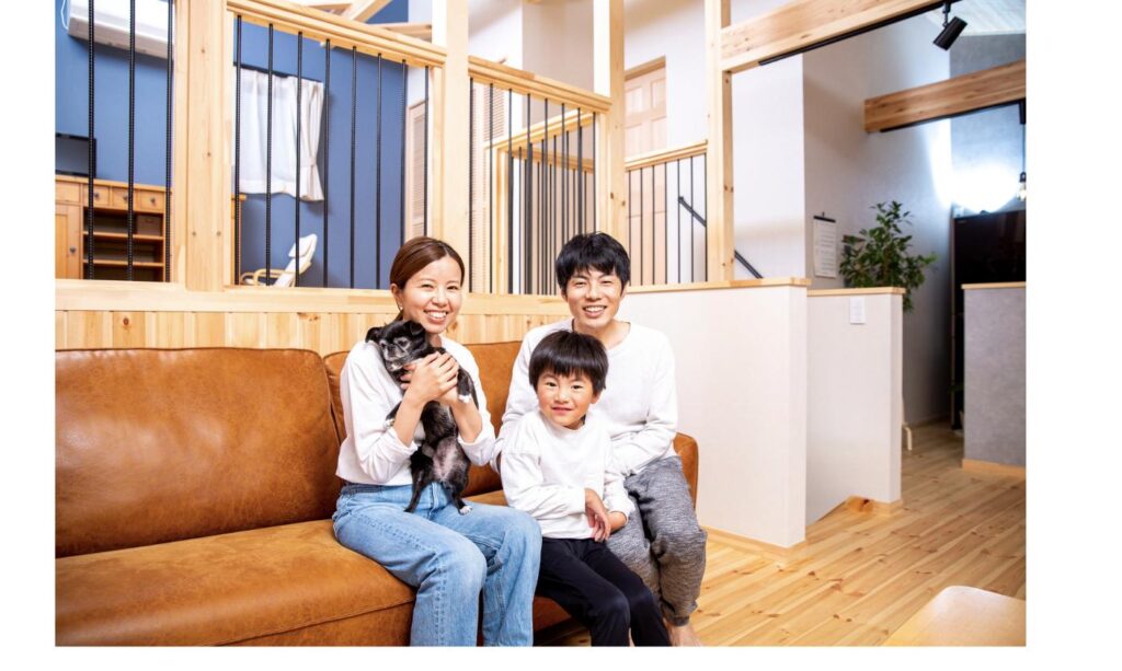 ソファで犬を抱いて笑顔の家族、野犬・保護収容出身の保護犬との穏やかな暮らしをイメージ