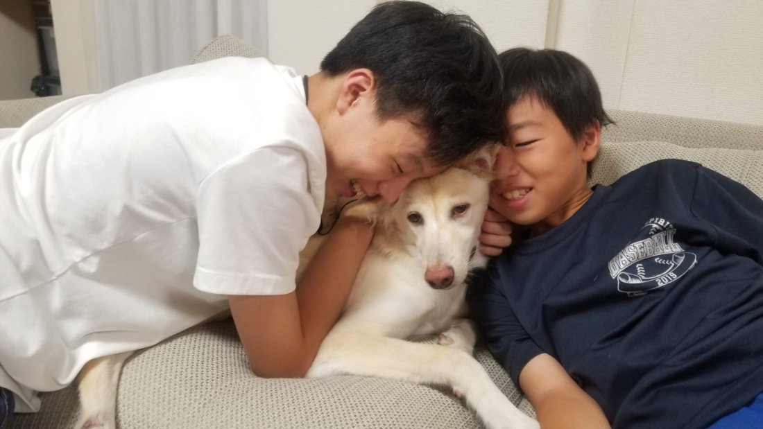 ソファーで息子さん二人に寄り添われるキナリ